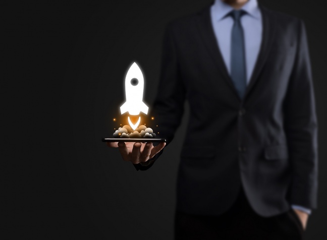startup-business-concept-businessman-holding-tablet-and-icon-rocket